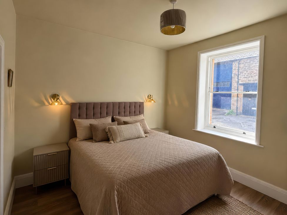 A bedroom with a bed and window at Holt Hall - Ground Floor Apartment in Matlock