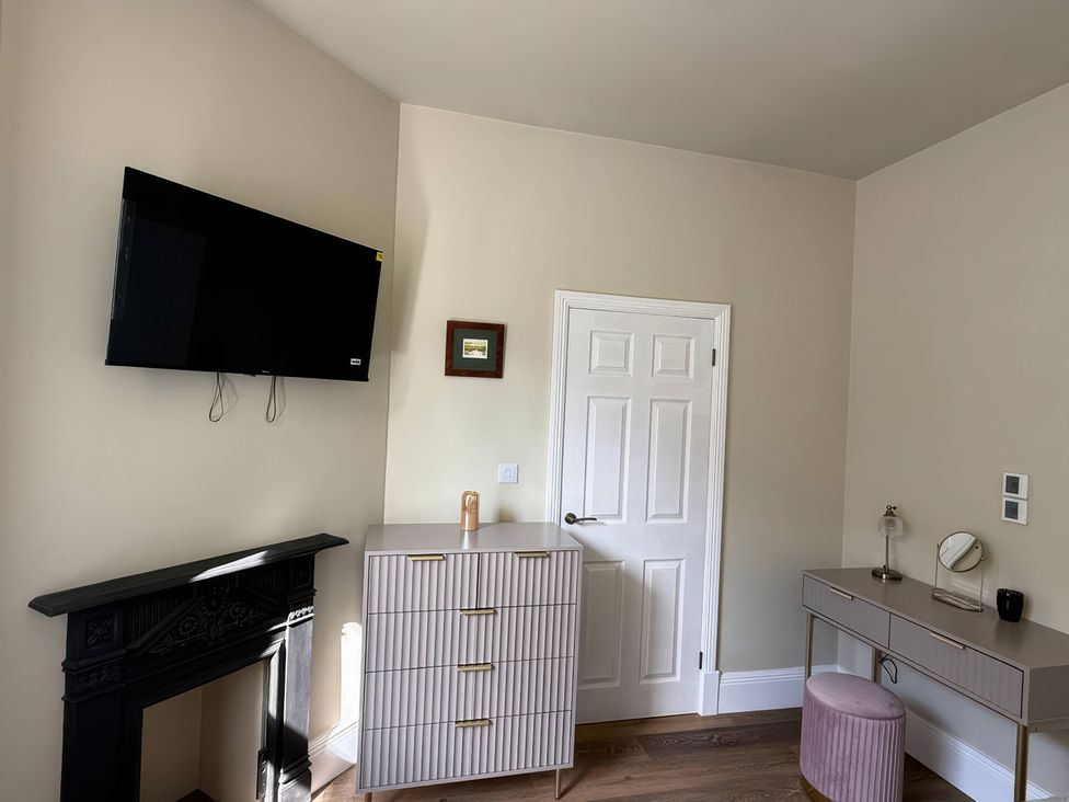 A bedroom with a television and chest of drawers at Holt Hall - Ground Floor Apartment in Matlock
