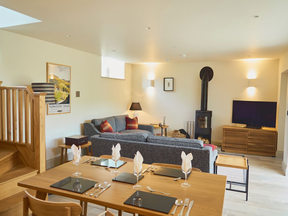 A living room with a sofa and dining area at The Reading Rooms Oughtershaw near Buckden
