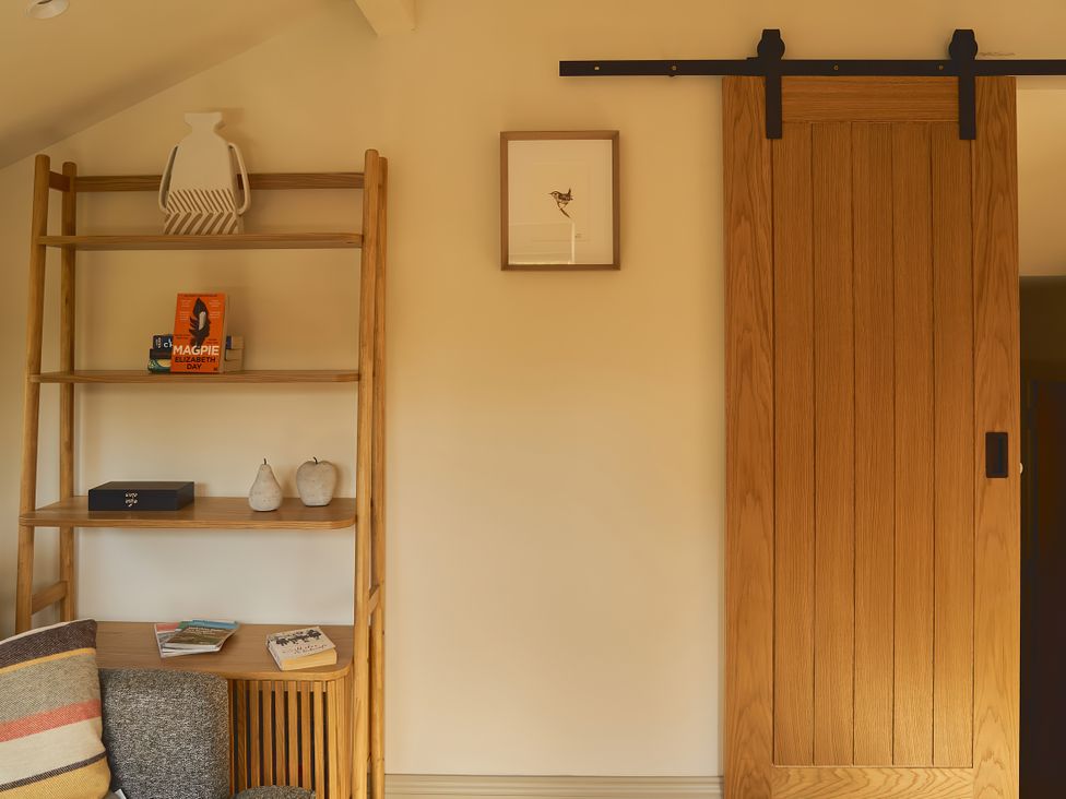 A living room with a shelf containing books and a sliding door at The Reading Rooms Oughtershaw near Buckden
