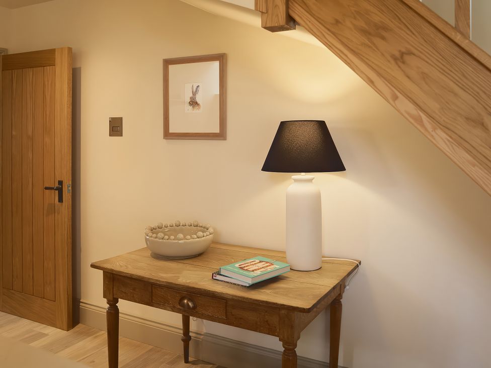 A hallway with a table, lamp, and bowl at The Reading Rooms in Oughtershaw near Buckden