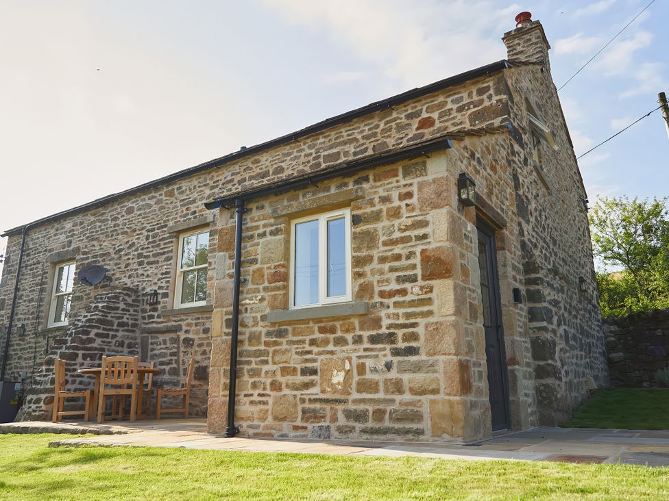 A stone cottage with outdoor seating at The Reading Rooms Oughtershaw near Buckden