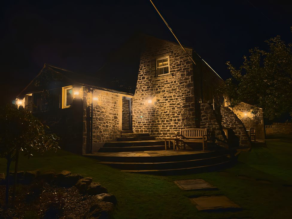A stone house with a pathway and bench at The Reading Rooms in Oughtershaw near Buckden