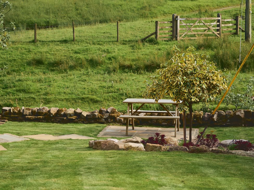 A garden with a picnic table and tree at The Reading Rooms in Oughtershaw near Buckden