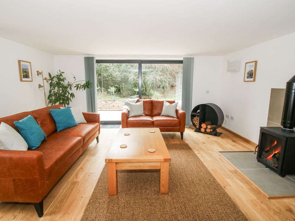 A living room with sofas, a table, and a fireplace at The Barn in Acton near Bishop's Castle