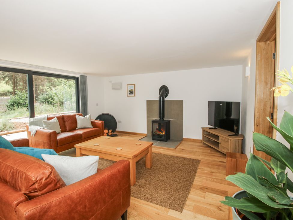 A living room with a sofa, coffee table, and fireplace at The Barn in Acton near Bishop's Castle