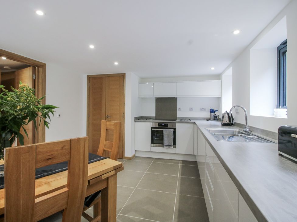 A kitchen with a dining table and oven at The Barn in Acton near Bishop's Castle