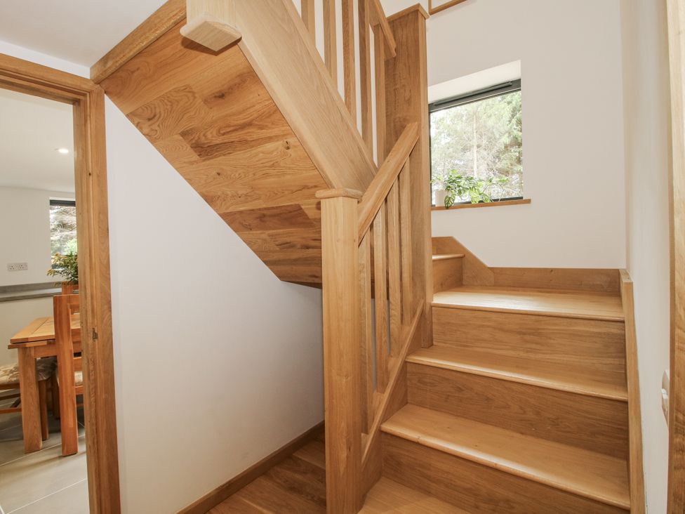 A staircase with wooden railing and a window at The Barn in Acton near Bishop's Castle