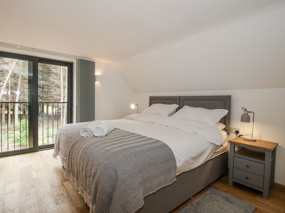 A bedroom with a bed and nightstand at The Barn in Acton near Bishop's Castle