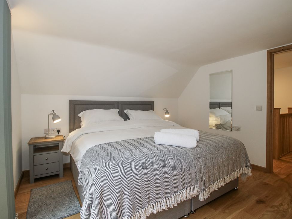 A bedroom with a bed and nightstand at The Barn in Acton near Bishop's Castle