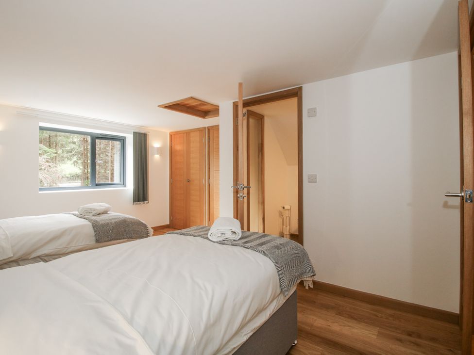A bedroom with two beds and a window at The Barn in Acton near Bishop's Castle