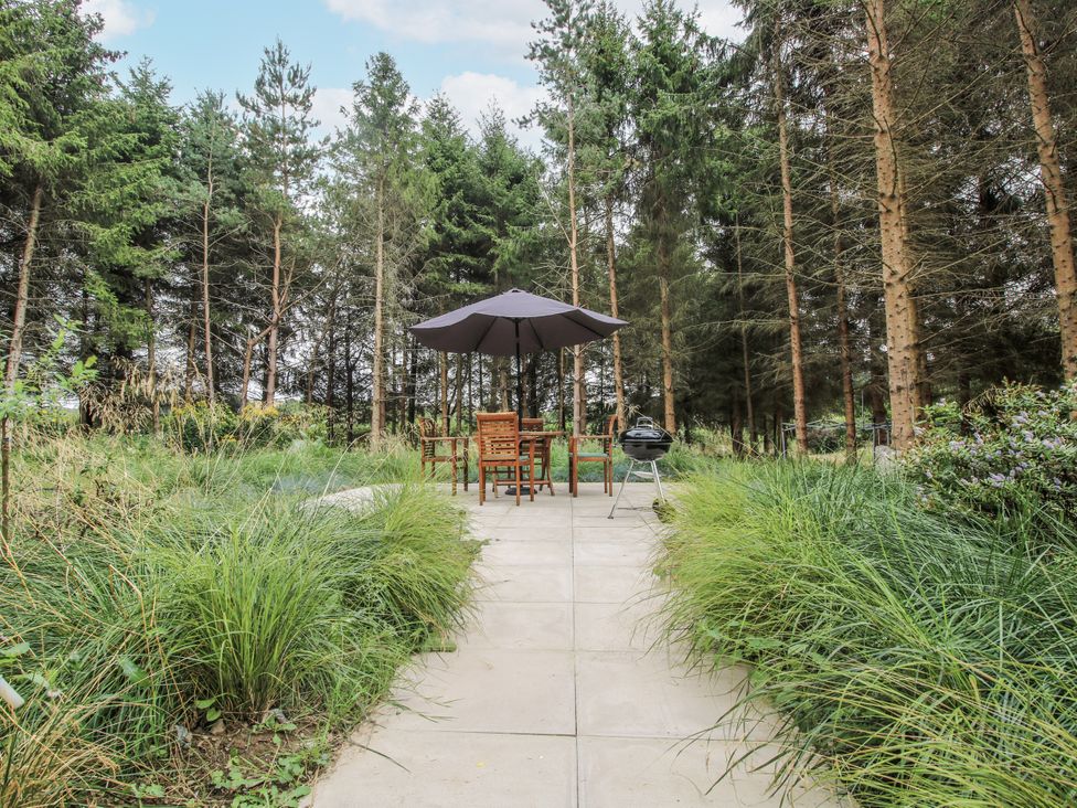A garden with a seating area and barbecue at The Barn in Acton near Bishop's Castle