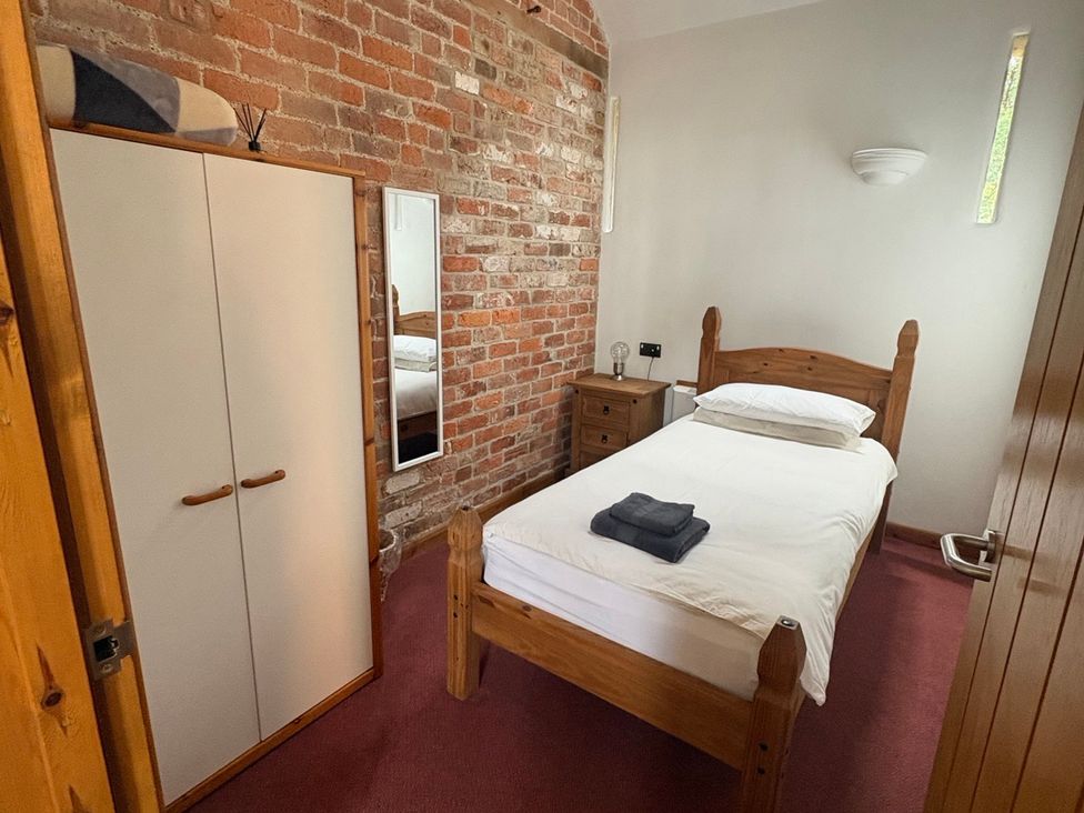 A bedroom with a single bed and wardrobe at Woodside Cottage in Kerry