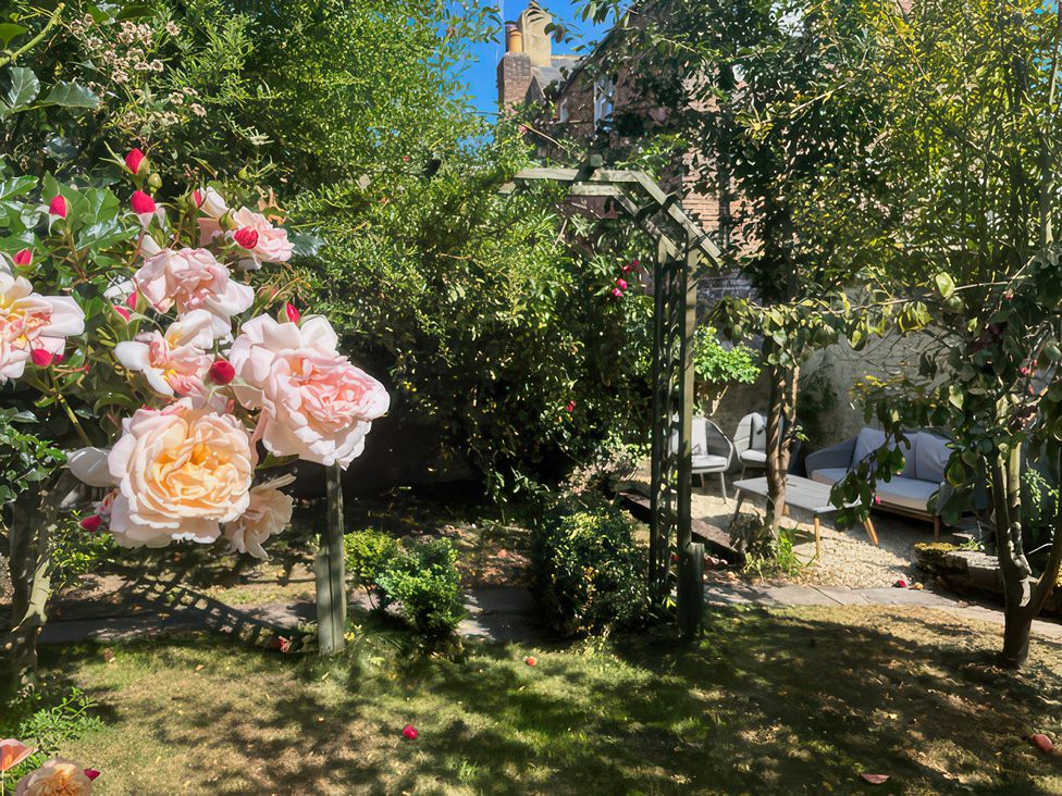 A garden with flowers and seating area at Field View Ruswarp