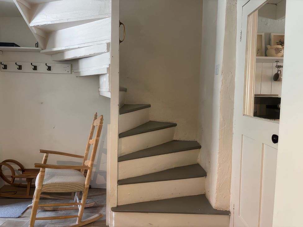 A staircase and rocking chair in an entrance hall at Field View in Ruswarp