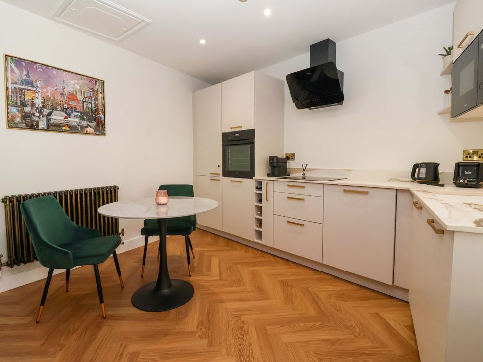 A kitchen with a round table and two chairs at The Old Bakehouse 