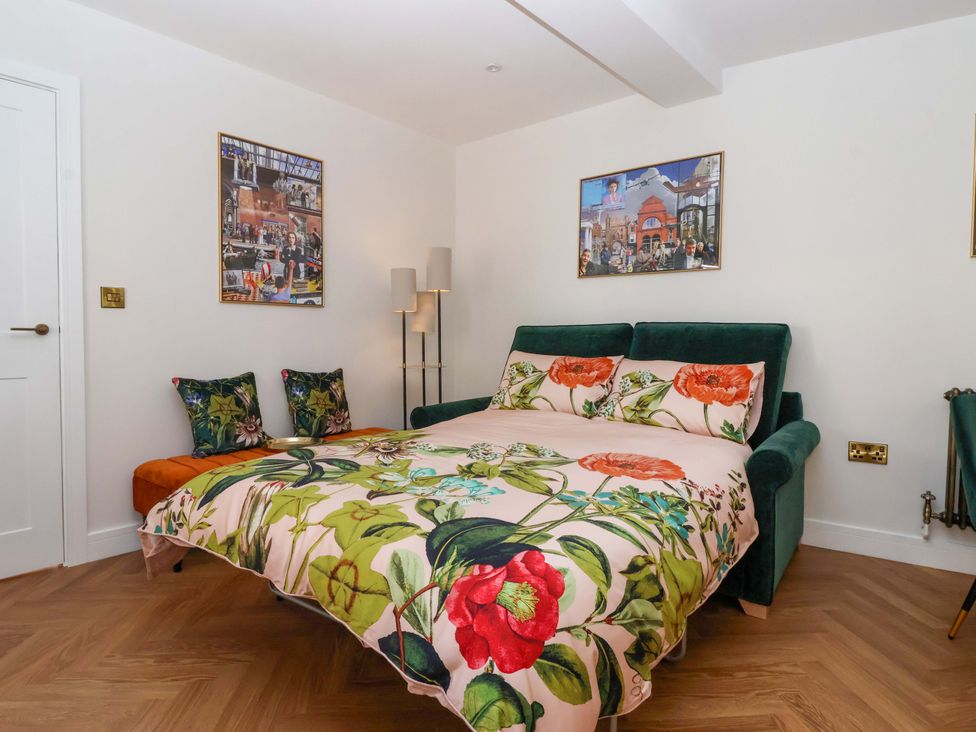 A bedroom with a bed and artwork on walls at The Old Bakehouse