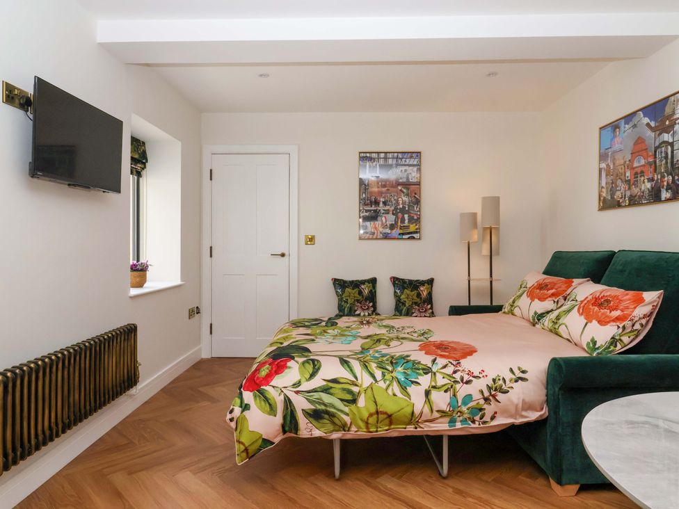 A bedroom with a bed and television at The Old Bakehouse