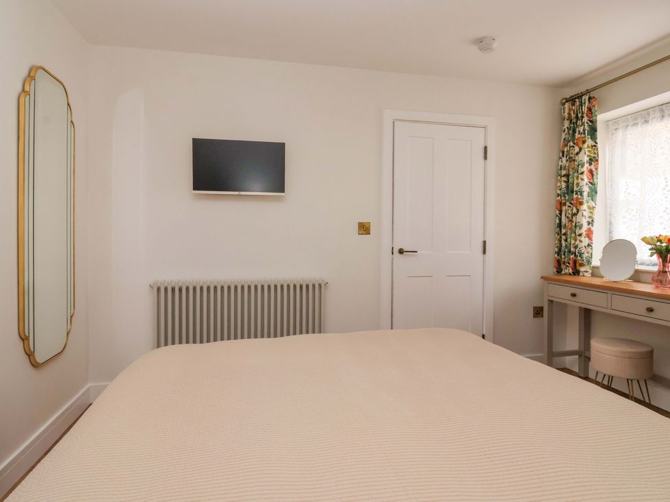 A bedroom with a bed and a mirror at The Old Bakehouse in 