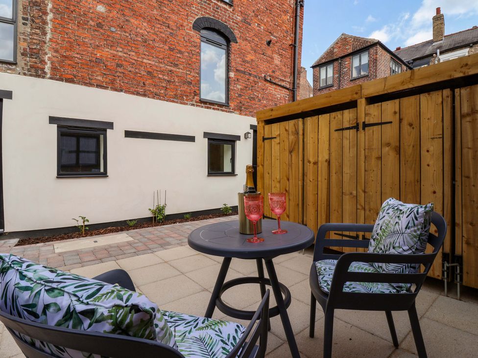 An outdoor seating area with chairs and a table at The Old Bakehouse in 