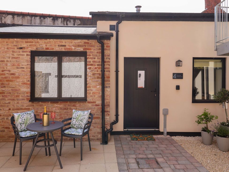 A patio area with seating and a door at The Old Bakehouse in 