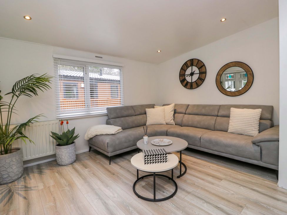 A living room with a grey sofa and coffee table at Cosy Corner, White Cross Bay near Troutbeck Bridge