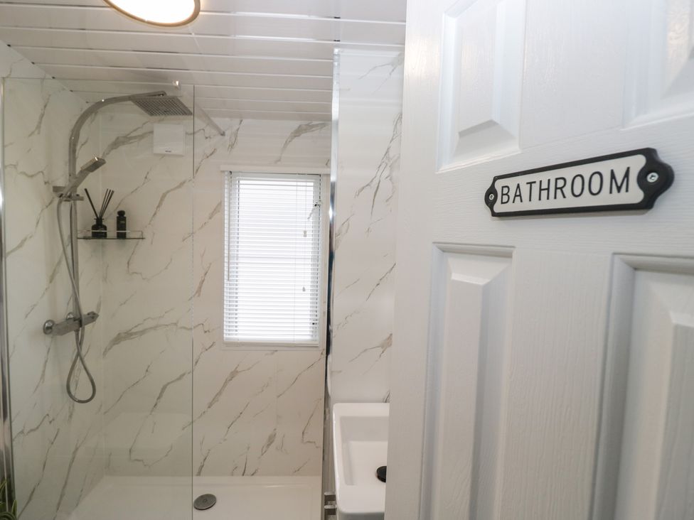 A bathroom featuring a shower and sink at Cosy Corner in White Cross Bay near Troutbeck Bridge