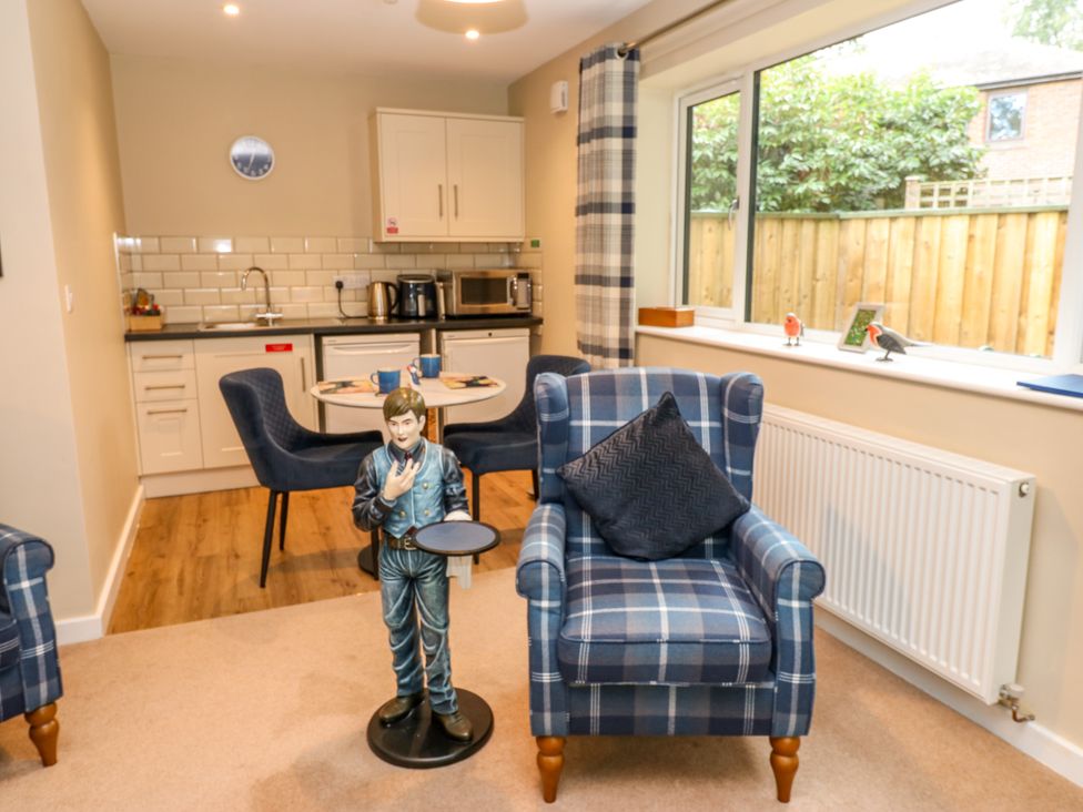 A living room with a table and chairs and a statue at The Nest in Wetheral