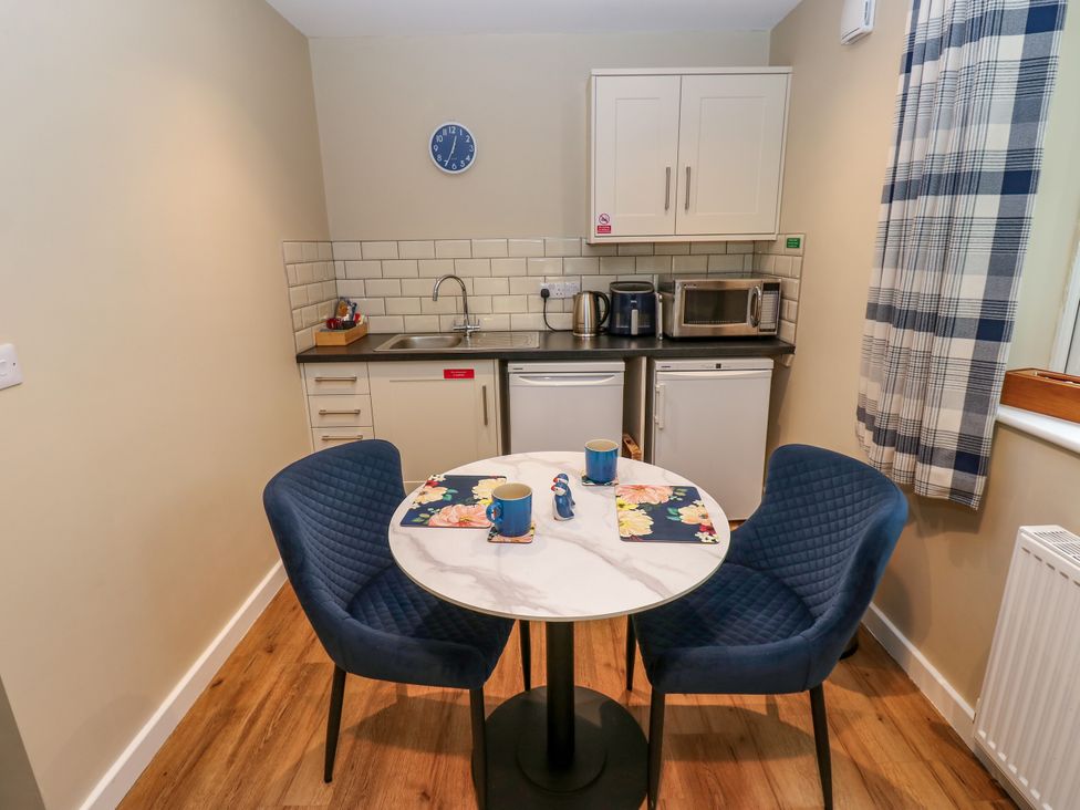 A kitchen with a table and chairs at The Nest Wetheral
