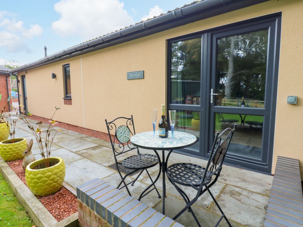 An outdoor seating area with a table and chairs at The Nest in Wetheral