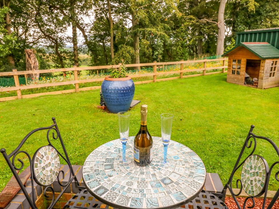 A table with champagne and glasses in a garden at The Nest in Wetheral