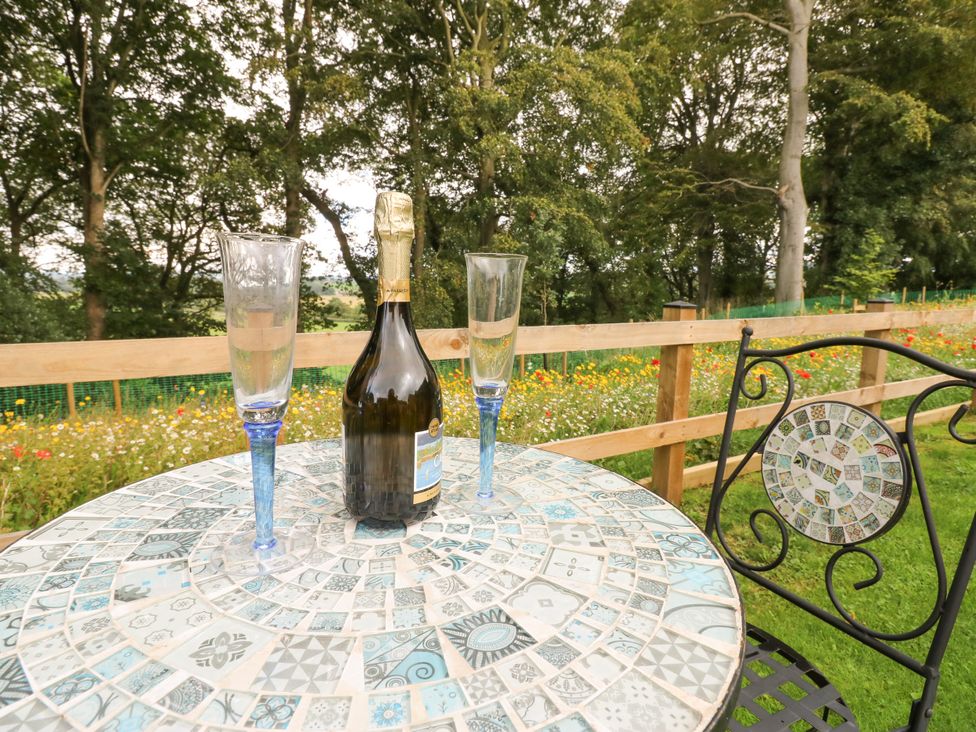 A table with champagne and glasses in a garden at The Nest in Wetheral