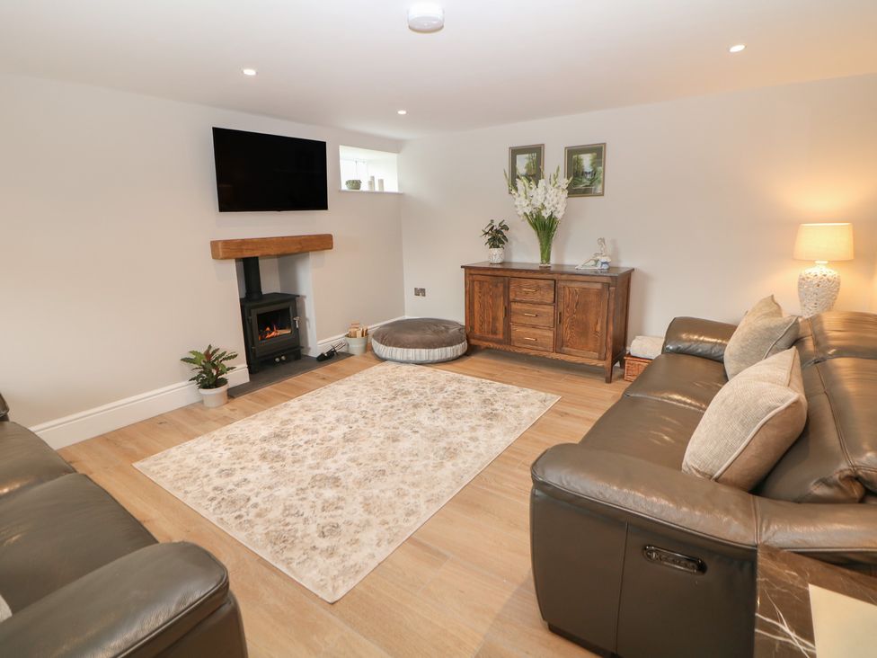 A living room with a television and sofa at Coach House in Matlock