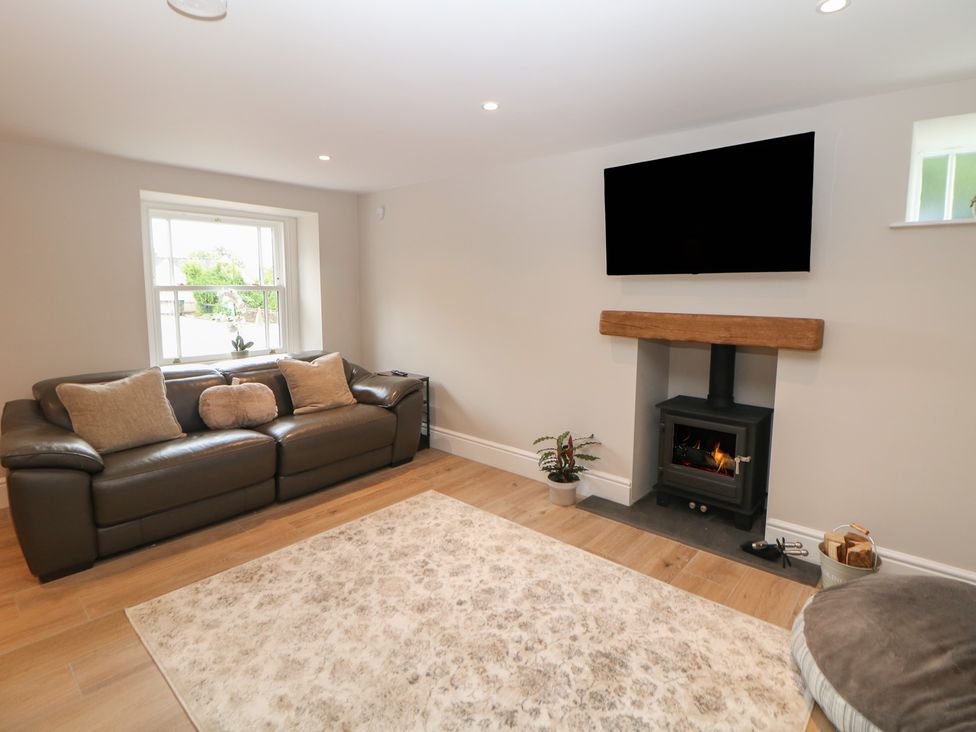 A living room with a sofa and television at Coach House in Matlock