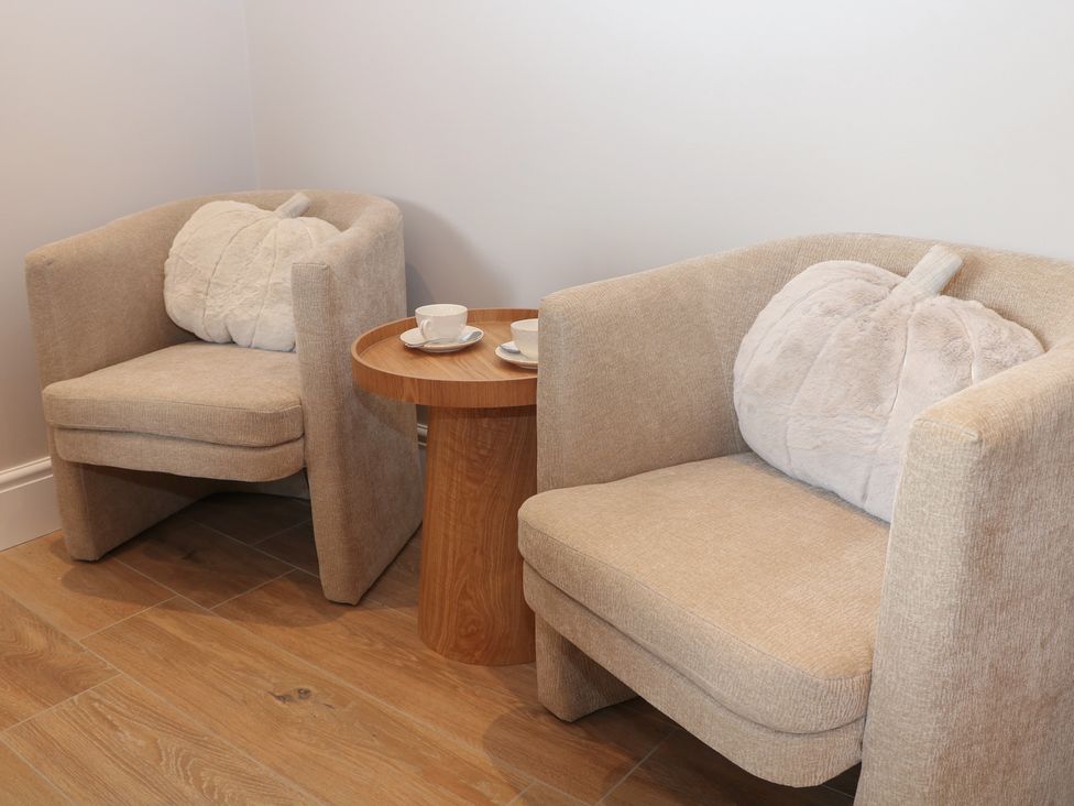 Two chairs and a table with cups in a living room at Coach House Matlock