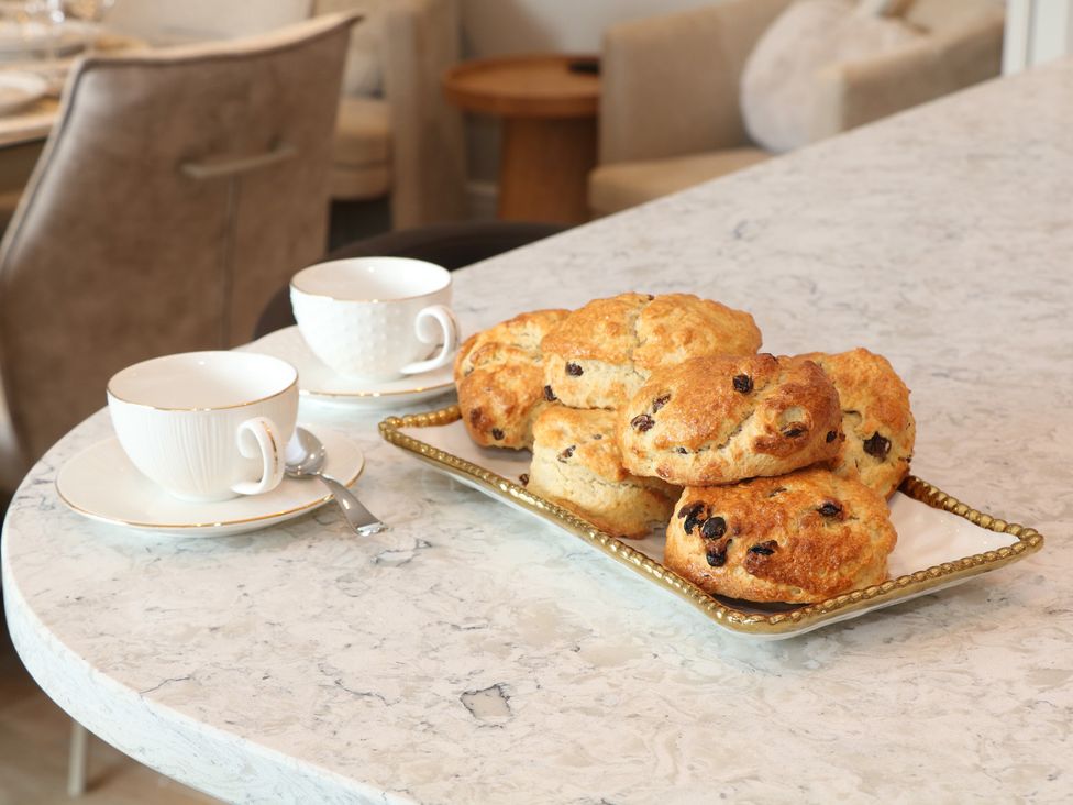 A dining room table with scones and teacups at Coach House in Matlock