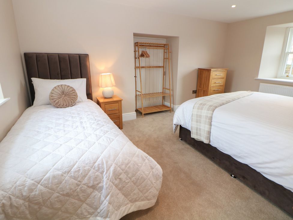 A bedroom with a single bed and a double bed at Coach House in Matlock