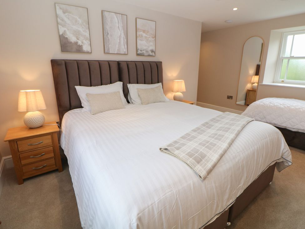 A bedroom with a large bed and nightstands at Coach House in Matlock