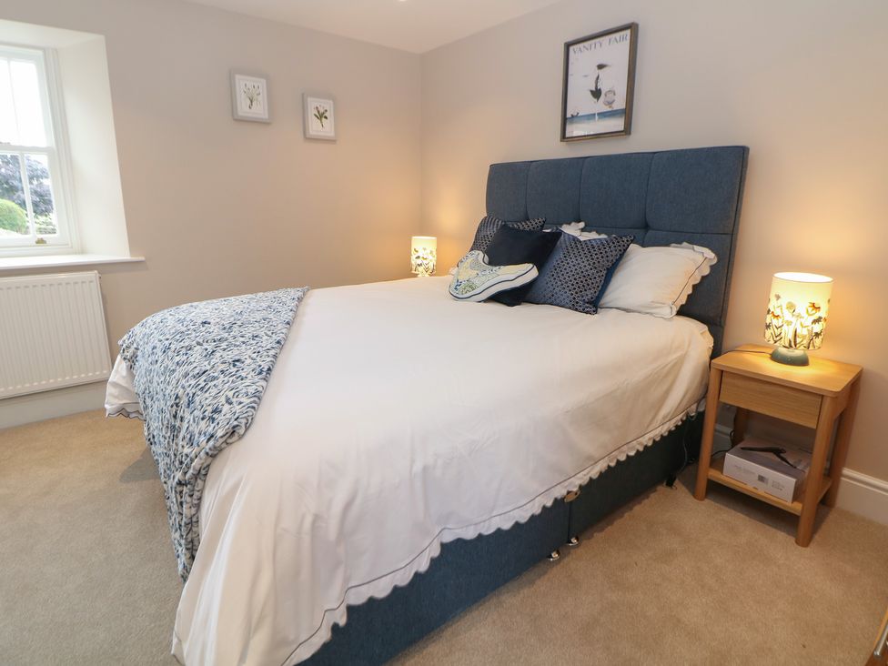 A bedroom with a bed and bedside table at Coach House in Matlock