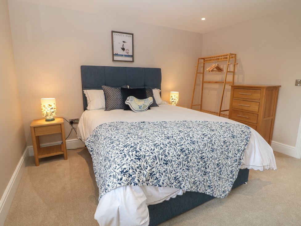 A bedroom with a bed and dresser at Coach House in Matlock