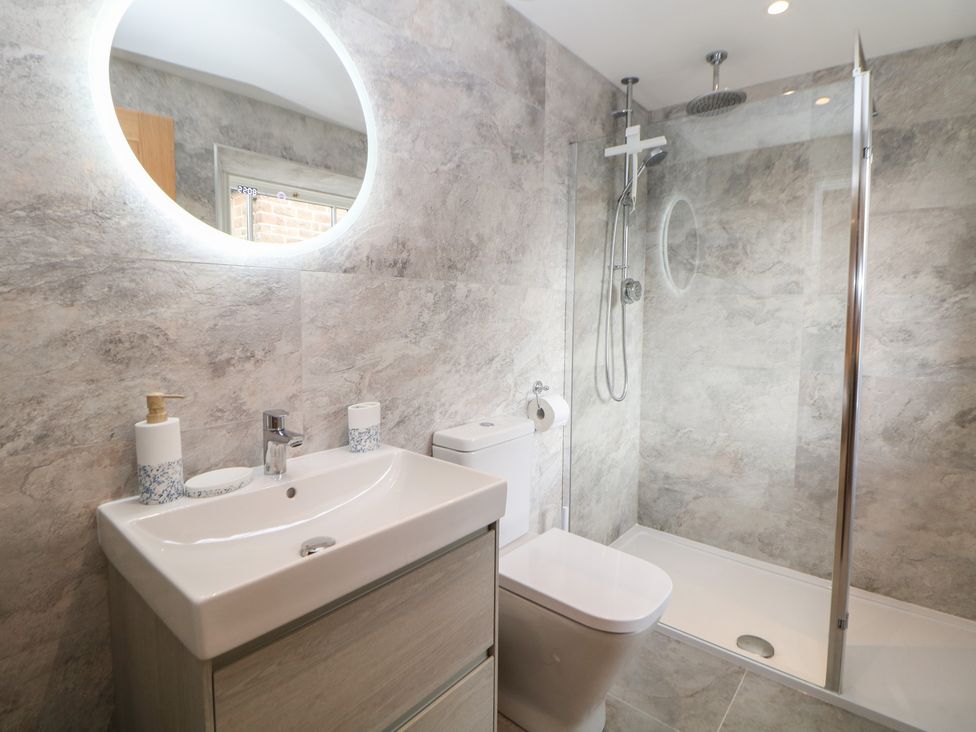 A bathroom with a sink, toilet, and shower at Coach House in Matlock