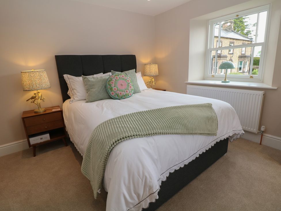 A bedroom with a bed and a lamp at Coach House Matlock