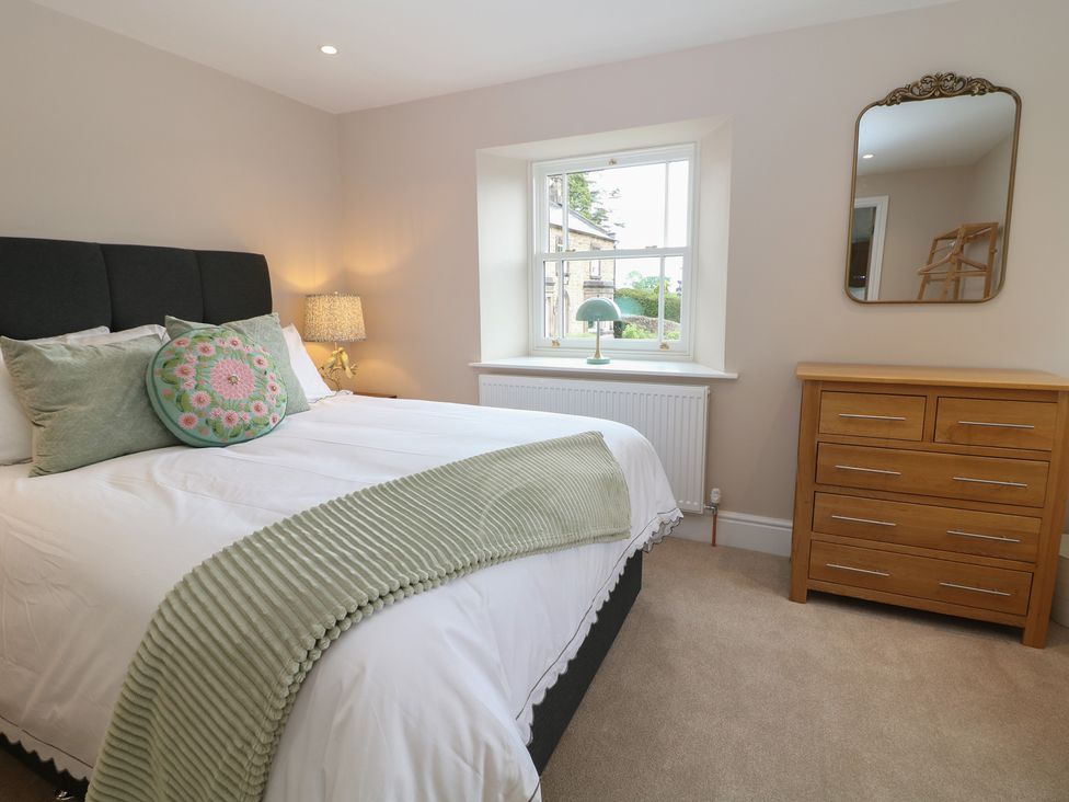 A bedroom with a bed and dresser at Coach House in Matlock