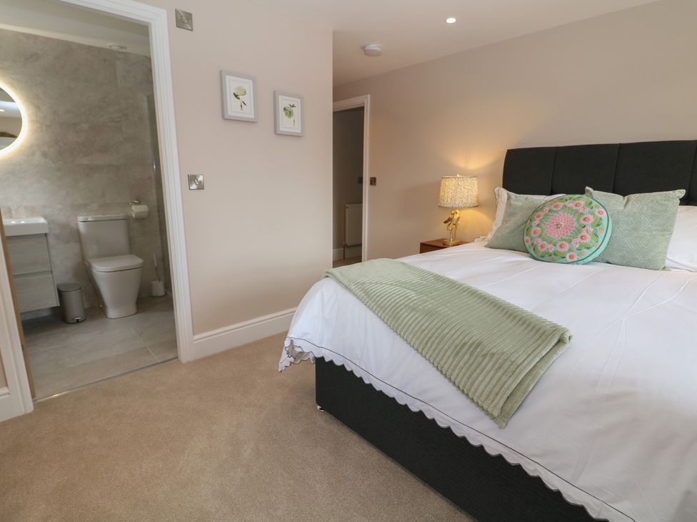 A bedroom with a bed and bathroom access at Coach House in Matlock