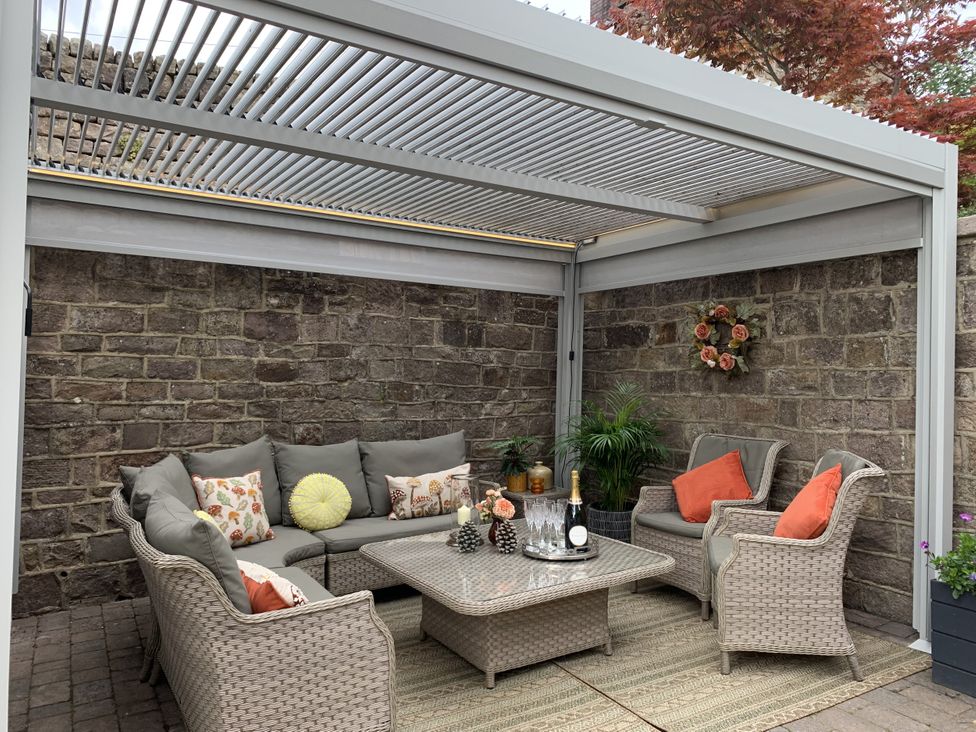 An outdoor seating area with a sofa and coffee table at The Coach House in Holloway