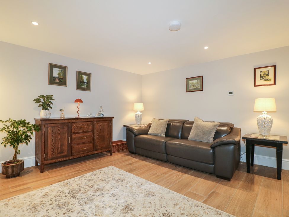 A living room with a sofa and side tables at The Coach House in Holloway
