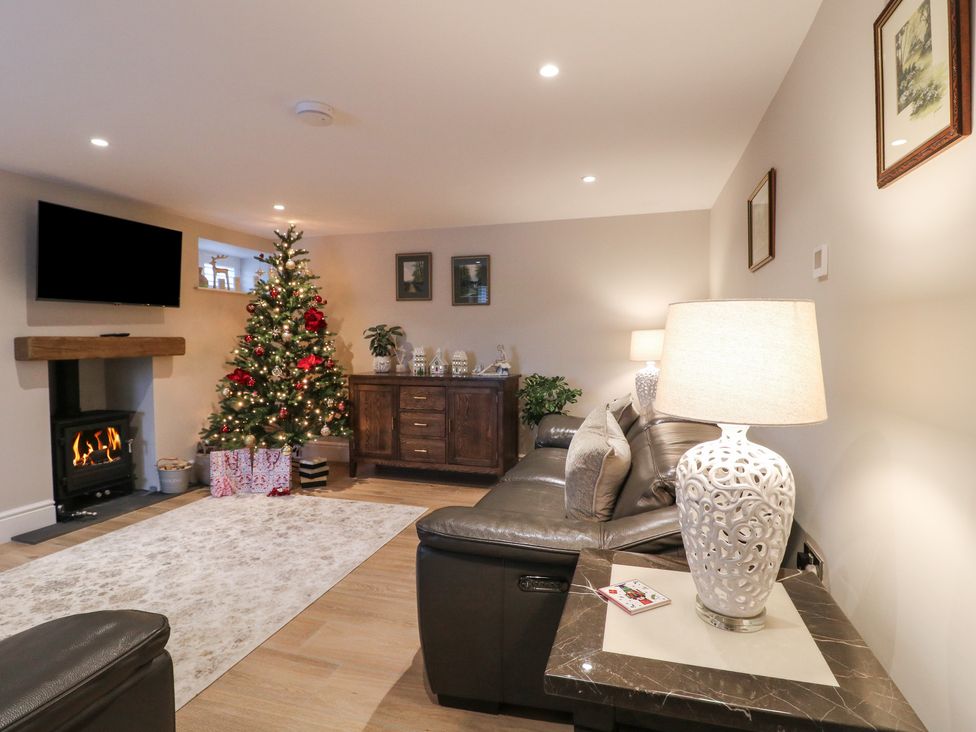 A living room with a Christmas tree and a fireplace at The Coach House in Holloway