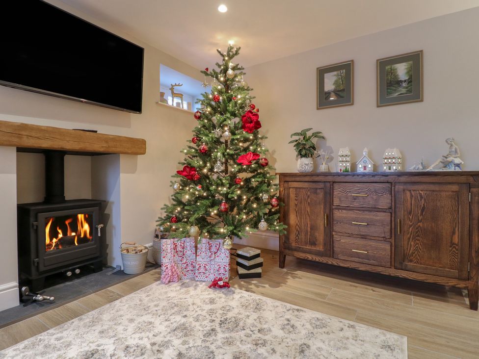 A living room with a Christmas tree and fireplace at The Coach House in Holloway