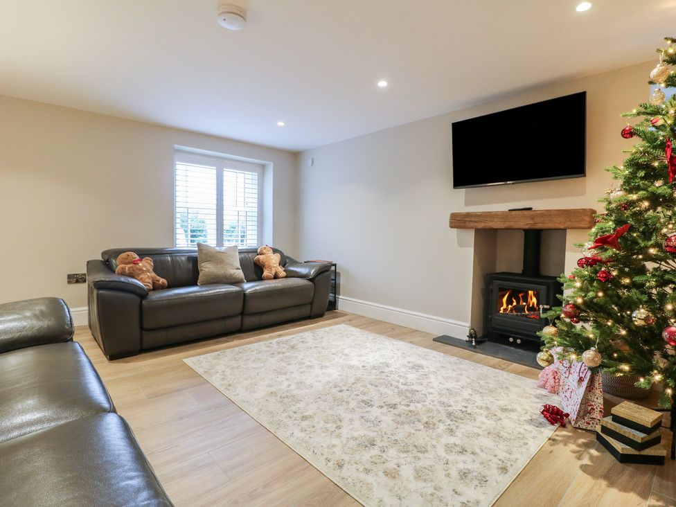 A living room with sofa and fireplace at The Coach House in Holloway