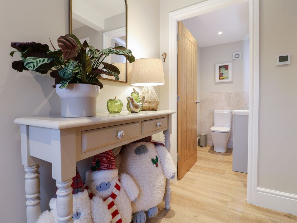 A hallway with a console table and a mirror at The Coach House in Holloway
